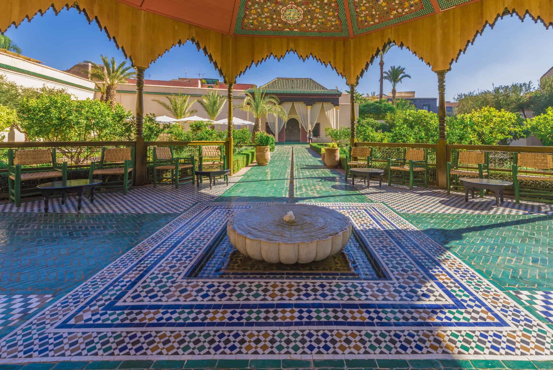 Jonction entre détente et authenticité dans un jardin marocain traditionnel avec fontaine et pergola.